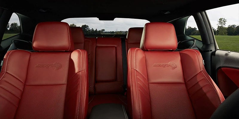 Interior view of a car with red leather seats, some featuring an "SRT Hellcat" emblem.