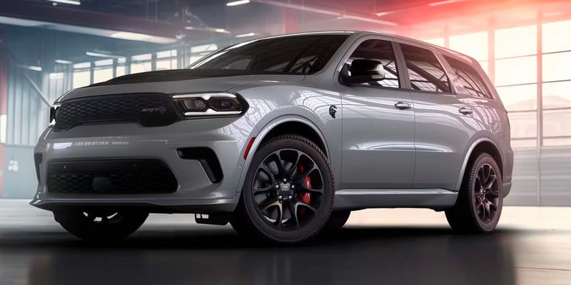 A silver Dodge Durango SUV with dark wheels and red brake calipers, parked in an indoor garage.
