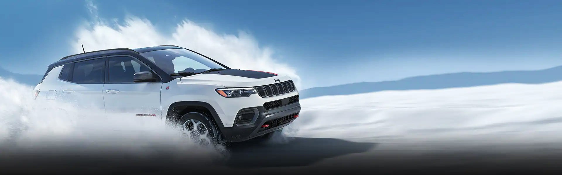 White crossover SUV, with a black roof and red hood stripe, driving through water, creating a splash.